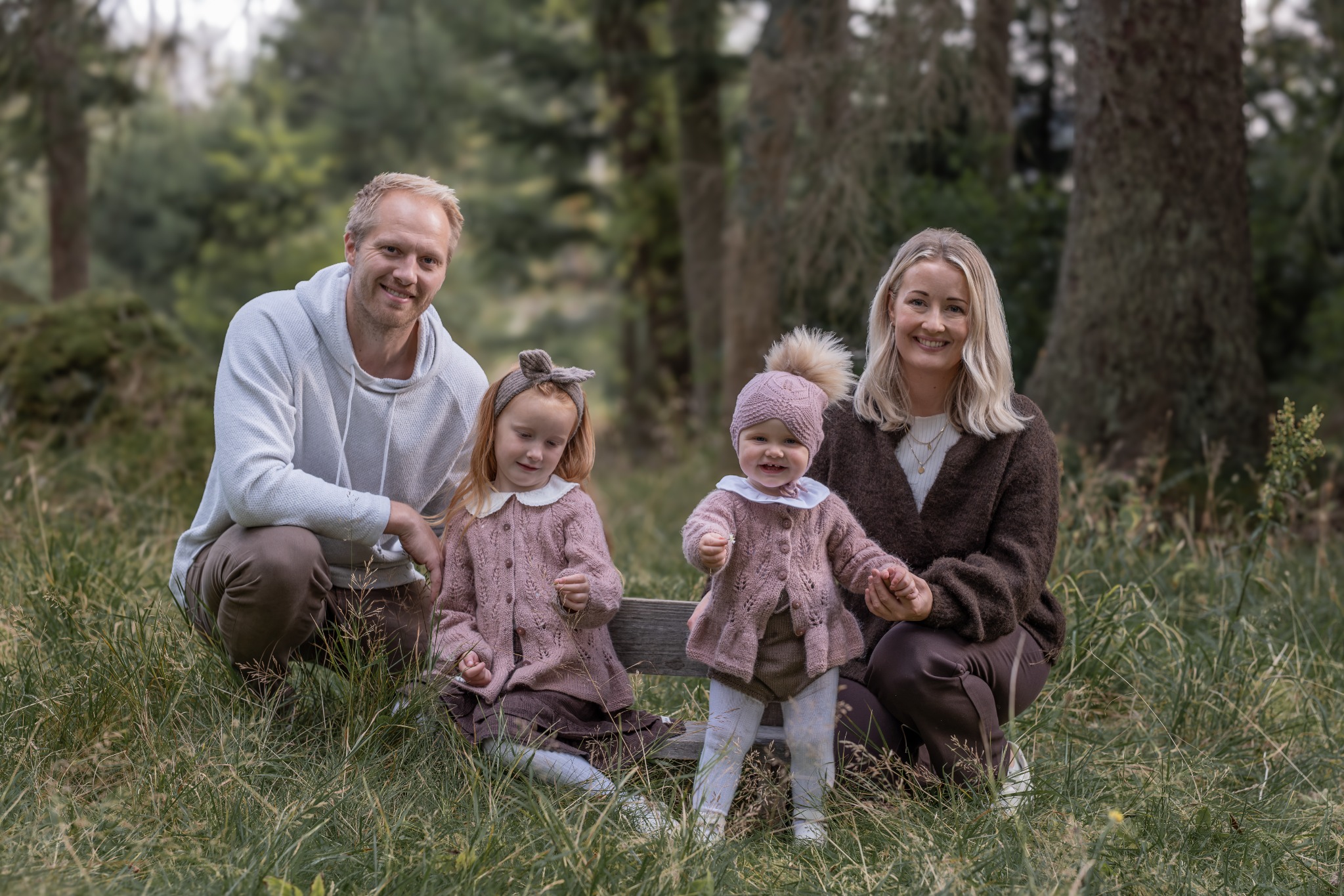 Familie med to barn samla ute i skogen